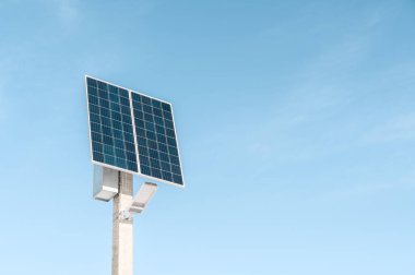 Bir güneş paneli ve mavi gökyüzü arka planında bir LED lambadan oluşan bir sokak aydınlatma sistemi. Güneş enerjisi sistemi, fotovoltaik, alternatif elektrik kaynağı - sürdürülebilir kaynak kavramı.