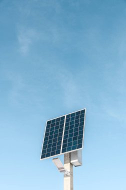 Bir güneş paneli ve mavi gökyüzü arka planında bir LED lambadan oluşan bir sokak aydınlatma sistemi. Güneş enerjisi sistemi, fotovoltaik, alternatif elektrik kaynağı - sürdürülebilir kaynak kavramı.