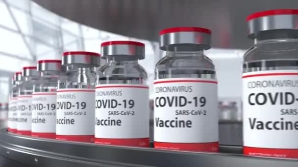 Bottles with COVID-19 vaccine on conveyor line at pharmaceutical industry loop — Stockvideo