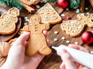 Tahta arka planda Noel kurabiyeleri. Kurabiye boyama işlemi.