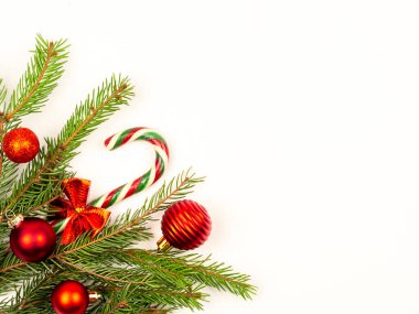 Beyaz arka planda kırmızı topları olan ladin dalları. Neşeli Noel arkaplanı.