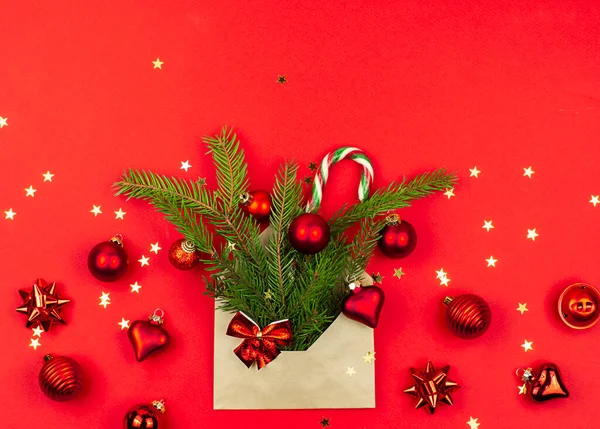 Weihnachtsbaumspielzeug Caramel Cane Santa Einem Papierumschlag Auf Rotem Hintergrund Konzept — Stockfoto