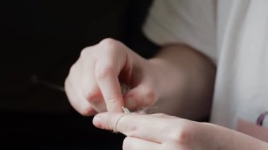 Şırıngayla örgü örme süreci. Şırıngayla örgü ören genç bir kızın elleri. El yapımı konsept, hobi, rahatlama.