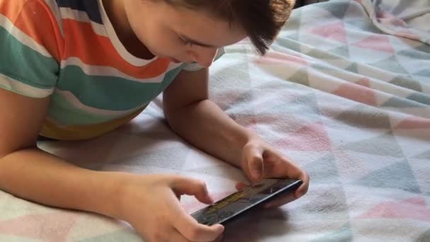 11歳の少年は自宅で電話をしています — ストック動画