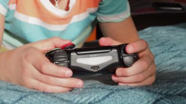 Genç bir çocuk kumanda kolu tutuyor. Konsolu çalma süreci. Rusya Moskova 20.02.2022