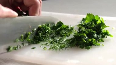 Taze otları doğrayan genç bir kadının elleri. Ev yapımı yemek hazırlama süreci. Evde ev yemeği kavramı. Evde kal..