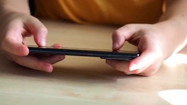 Bir genç akıllı telefondan oyun oynuyor..