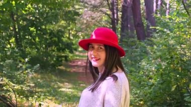 Güneşli bir sonbahar gününde ormanda poz veren güzel bir kadın.