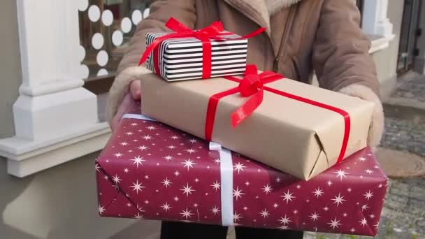 Teengirl κρατώντας ένα σύνολο χριστουγεννιάτικα δώρα κοντά στο παράθυρο καταστήματα — Αρχείο Βίντεο