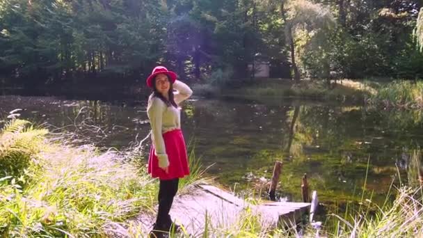 Όμορφη γυναίκα ποζάρουν στο δάσος σε μια ηλιόλουστη μέρα του φθινοπώρου — Αρχείο Βίντεο
