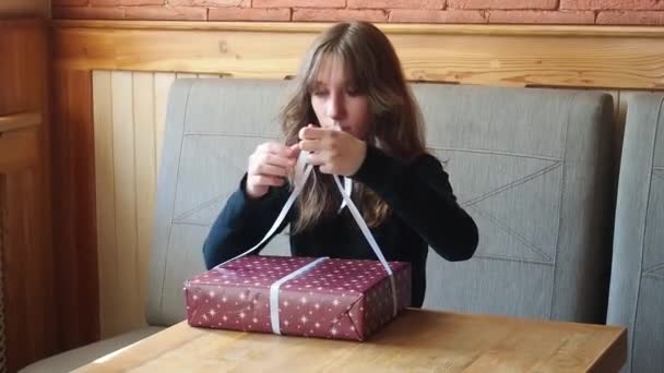 Ragazza lega un fiocco su un regalo di Natale — Video Stock