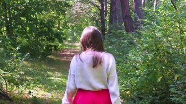 Güneşli bir sonbahar gününde ormanda poz veren güzel bir kadın.