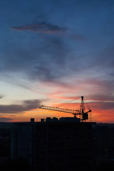 Tower crane and building construction site silhouette at sunrise. — Stock Photo, Image