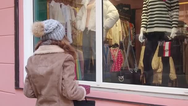 Teengirl hält eine Reihe von Weihnachtsgeschenken in der Nähe von Schaufenstern — Stockvideo
