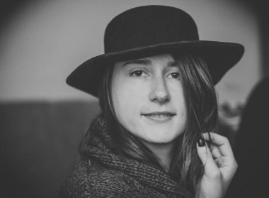 Evde makyajsız mutlu bir kadın var.