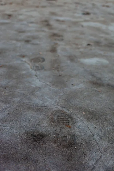 Kurumuş Toprak Dokusu Insan Izleri Çatlak Oyukları Olan Gri Bir — Stok fotoğraf