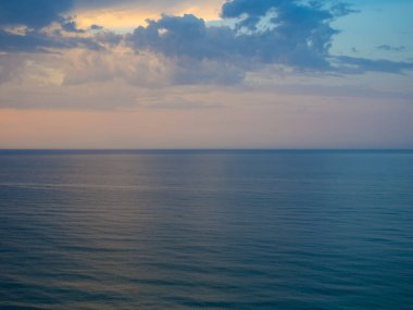 Bulutlu gökyüzü ve dalgalı deniz manzarası