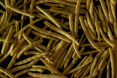 Yedinci adım. Fırın tepsisine fasulye koy. Kavrulmuş fasulye. Tabakta sarı ve yeşil fasulye, üst manzara. DIY. Sebze pişirme.