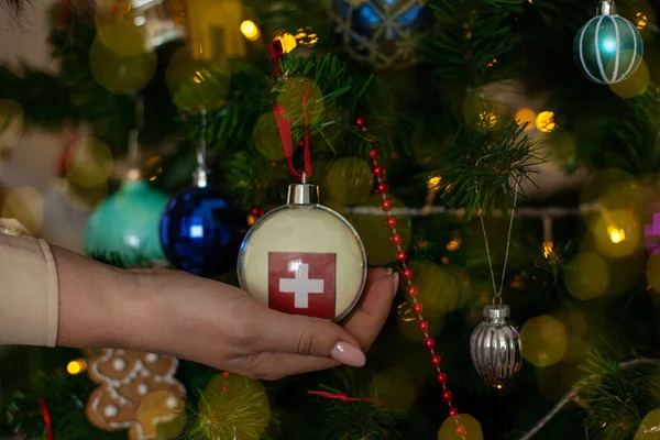 Close Girls Hand Holding Christmas Ball Fir Tree Flag Switzerland — стоковое фото