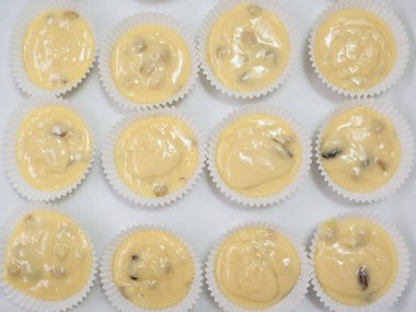 Kek hamuruyla dolu kağıt kutular, pişirilmeye hazır. Kuru üzümlü kek yapmak. Ev yapımı pişirme. Kek, turta ve bisküvi yapmak için adım at. Pişirme işlemi adım adım.