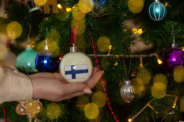 Крупным Планом Девушки Держат Руках Рождественский Бал Елки Флагом Финляндии — стоковое фото
