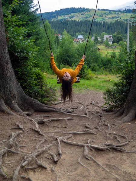 Woman Dark Hair Mustard Sweater Fun Sitting Swing Mountain View — ストック写真