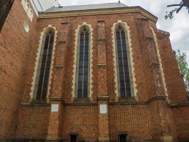 The Roman Catholic church of St. Bartholomew, Drohobych, Ukraine. Medieval Church 15-16th Century, gothic, baroque architecture. Side view. Red brick facade with large gothic windows.
