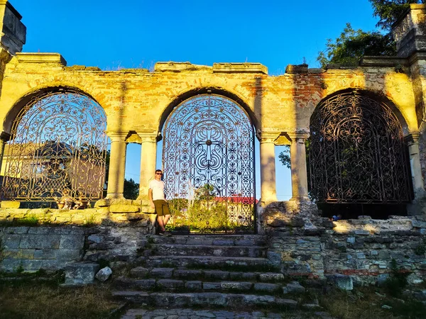 The ornate fence of Armenian Church in Kamianets-Podilskyi, Ukraine during sunset. Old wrought iron gate of the St Nicolas Armenian Church. The ruins of Church XV century, Kamianets-Podilskyi, Ukraine