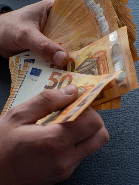 Background of the euros banknotes. Hands holding set of European money with a face value of 50 euros. The concept of business, Finance, and remuneration. Counting money for a rent, saving money.