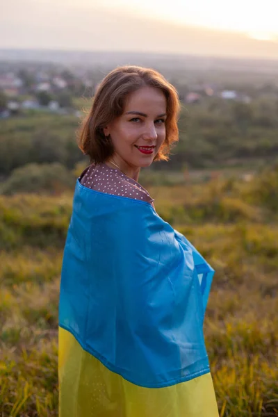 身着长裙的快乐女人 在日落的背景下 给自己罩上了乌克兰语的黄色和蓝色旗帜 乌克兰人反对战争 独立日 国旗日 宪法日 后视镜 — 图库照片