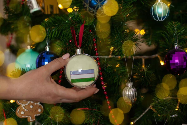 Крупным Планом Девушки Держат Руках Рождественский Бал Елки Флагом Узбекистана — стоковое фото