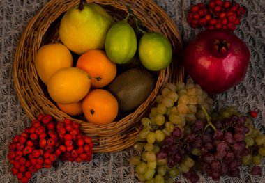 Taze sağlıklı meyveler masada bir sepette.