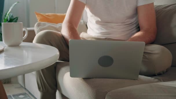 Среднее Отделение Молодого Человека Сидящего Дома Диване Использующего Ноутбук — стоковое видео