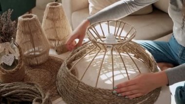 Kadın evde jüt ipten el yapımı diy lamba yapıyor.