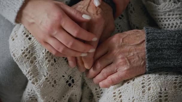 Old hands of elderly senior in the young female hands of caring daughter, slow motion. Support and care for elderly parents — Stock Video