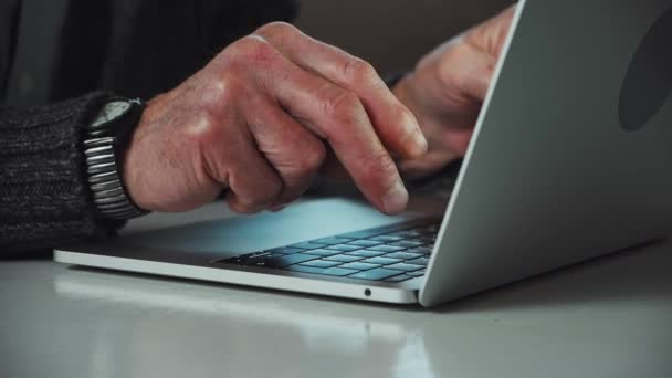 Close-up mãos de homem sênior digitando no teclado do laptop em casa — Vídeo de Stock