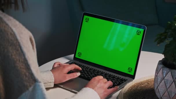 女人的手在家里的桌上用彩色键绿色屏幕笔记本电脑打字。轨道点 — 图库视频影像