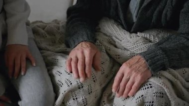 Yaşlı yaşlıların yaşlı elleri, genç bayanların ellerinde şefkatli kız, yavaş çekim. Yaşlı ebeveynlere destek ve bakım