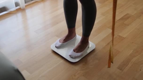 Vücut ağırlığını evde tartmaya çalışan kadın. — Stok video