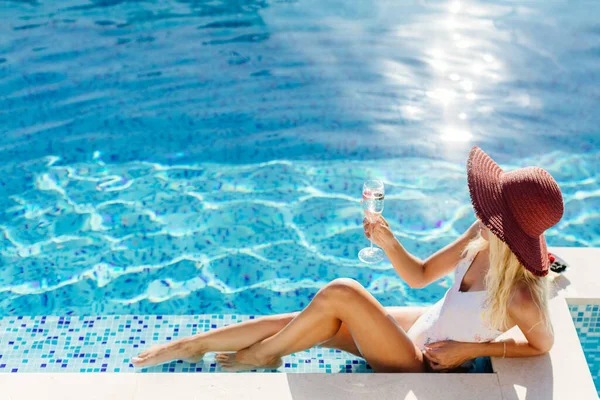 Wanita seksi santai di kolam renang dan minum sampanye — Stok Foto