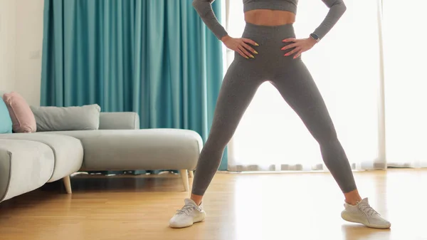 Atletische vrouw sport training thuis, squats. Thuistraining. — Stockfoto