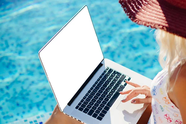Žena pomocí notebooku a práce na dálku v blízkosti bazénu — Stock fotografie