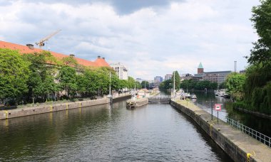 Berlin, Almanya, 31 Mayıs 2022 tarihi Muehlendammschleuse ve Rolandufer ve Maerkisches Ufer 'deki binalarla Spree Nehri manzarası.