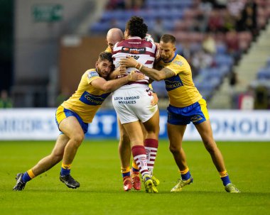  Ben Crooks #2 and Sam Royle #36 of Hull KR tackle Patrick Mago #10 of Wigan Warriors 