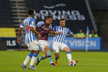 Josh Ruffels #14 of Huddersfield Town makes a clearance under pressure 
