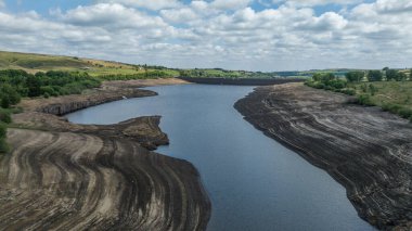 The reservoir banks are exposed as water is severally depleted at Baitings Reservoir near Ripponden West Yorkshire, UK on the 01/08/2022