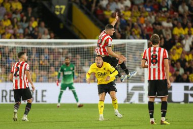 John Egan #12 of Sheffield United climbs over the back of Rey Manaj #9 of Watford 