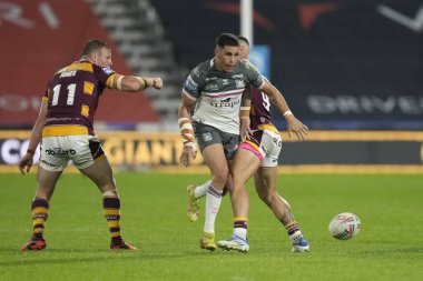 Will Smith #40 of Hull FC  chips the ball past Danny Levi #9 of Huddersfield Giants
