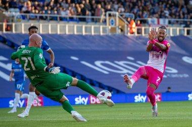 John Ruddy #21 of Birmingham City  clears the ball as Sorba Thomas #7 of Huddersfield Town covers his face 