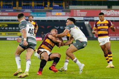 Darnell McIntosh #5 of Hull FC tackles Tui Lolohea #6 of Huddersfield Giants 